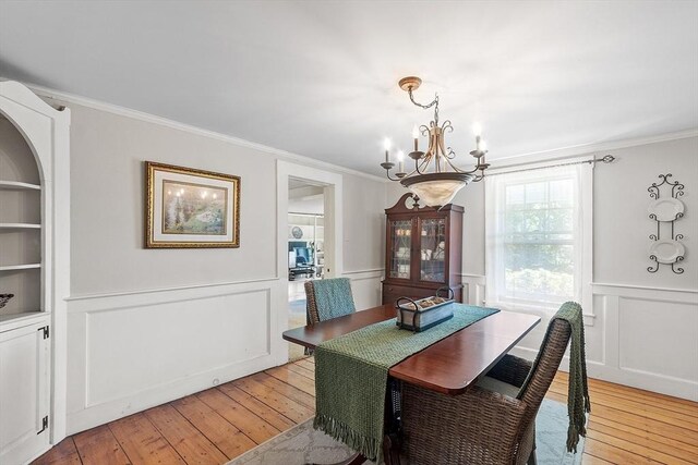 24 Summit Ave, Chelmsford, MA 01824 - dining room with a chandelier, ornamental molding, light wood finished floors, a decorative wall, and a wainscoted wall