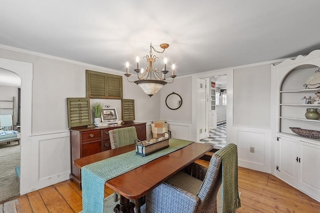 24 Summit Ave, Chelmsford, MA 01824 - dining room with light wood finished floors, a chandelier, ornamental molding, a decorative wall, and a wainscoted wall