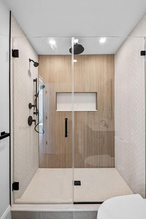 full bathroom featuring a stall shower and toilet