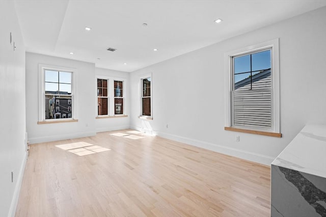 unfurnished living room featuring baseboards, light wood-style floors, and recessed lighting