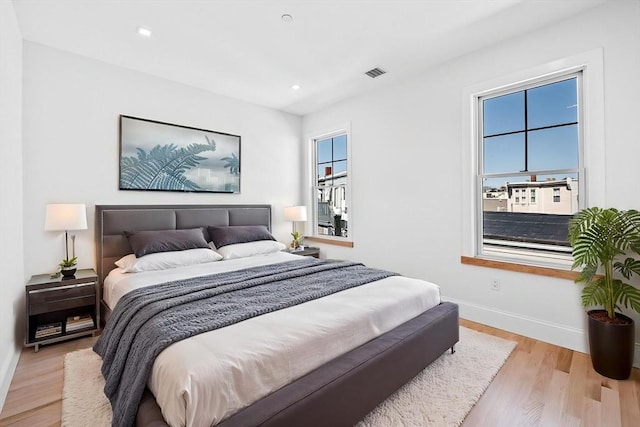 bedroom featuring baseboards, recessed lighting, visible vents, and wood finished floors