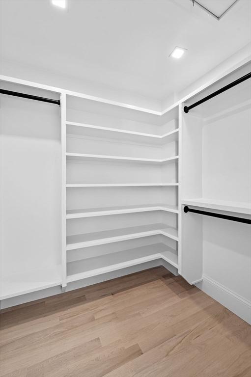 walk in closet with light wood-style flooring