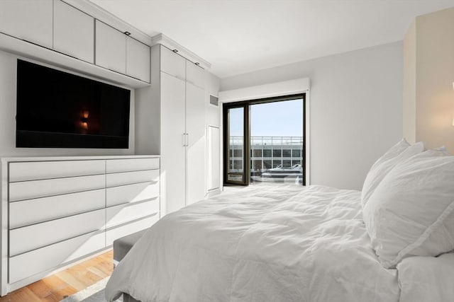 bedroom featuring access to exterior and light wood-type flooring