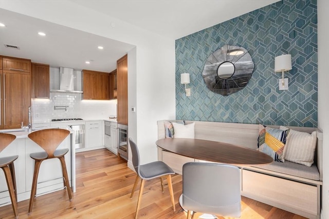 dining room with breakfast area, sink, and light wood-type flooring