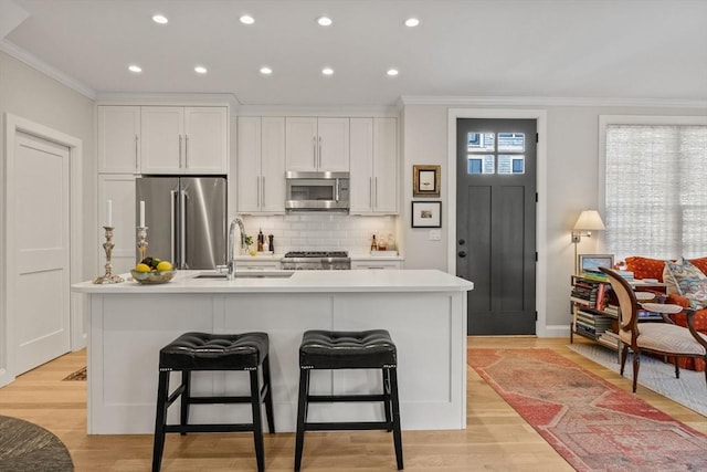 350 Bradford St Unit 7, Provincetown, MA 02657 - kitchen featuring appliances with stainless steel finishes, ornamental molding, a center island with sink, recessed lighting, and backsplash
