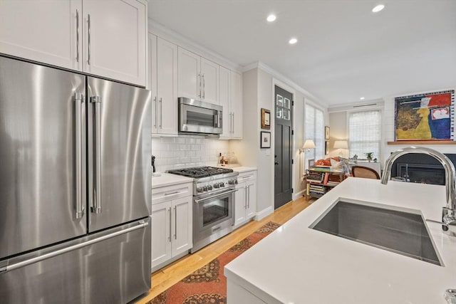350 Bradford St Unit 7, Provincetown, MA 02657 - kitchen featuring high end appliances, recessed lighting, light wood-style floors, white cabinets, and tasteful backsplash