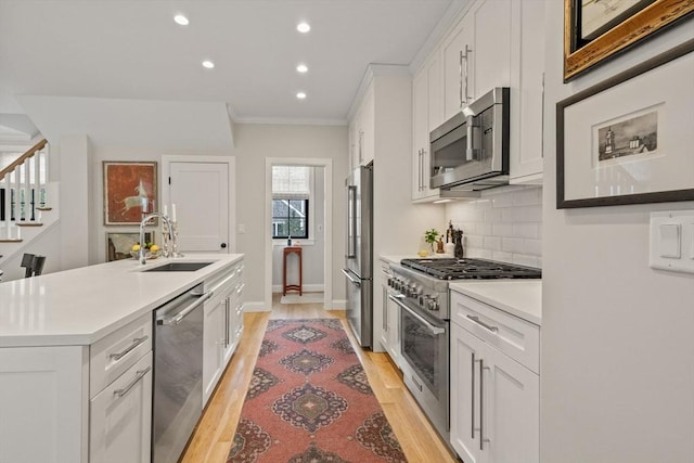 350 Bradford St Unit 7, Provincetown, MA 02657 - kitchen featuring high end appliances, recessed lighting, white cabinetry, light wood-style floors, and ornamental molding