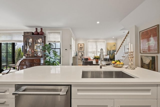 350 Bradford St Unit 7, Provincetown, MA 02657 - kitchen with stainless steel dishwasher, light countertops, ornamental molding, white cabinets, and open floor plan