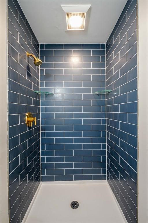 full bathroom featuring visible vents and tiled shower