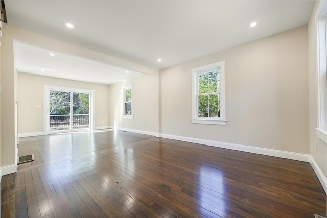 spare room with hardwood / wood-style floors, baseboards, and a wealth of natural light