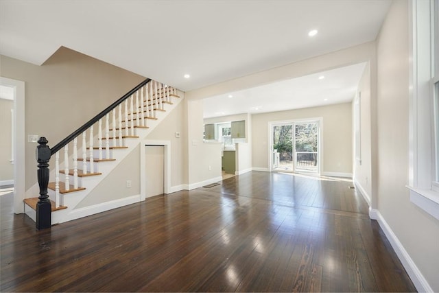 unfurnished living room featuring recessed lighting, stairs, baseboards, and wood-type flooring