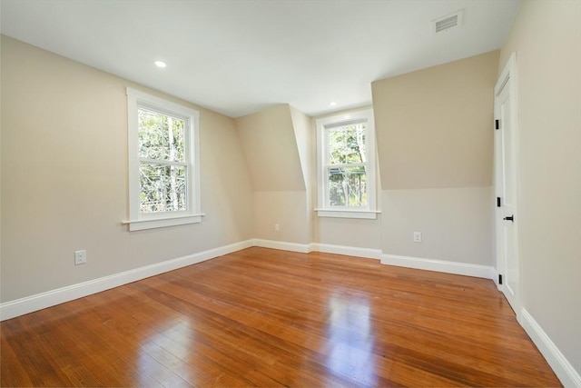 empty room with visible vents, baseboards, and wood finished floors