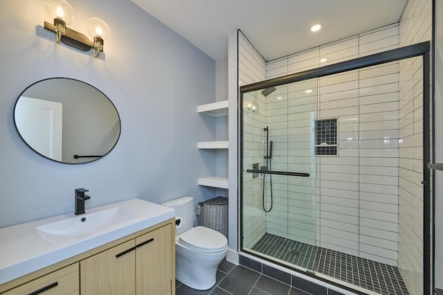 bathroom featuring toilet, a shower stall, vanity, and tile patterned floors
