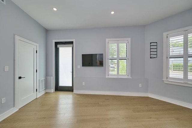 unfurnished living room with plenty of natural light, light wood-type flooring, recessed lighting, and baseboards