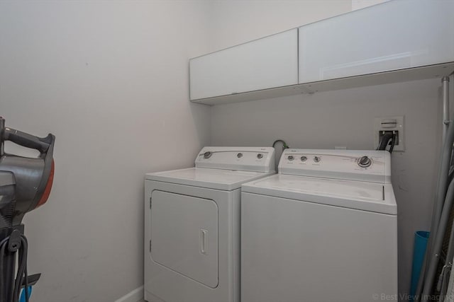 laundry room featuring cabinet space, washing machine and dryer, and baseboards