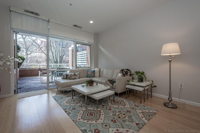 living area with wood finished floors, baseboards, and recessed lighting