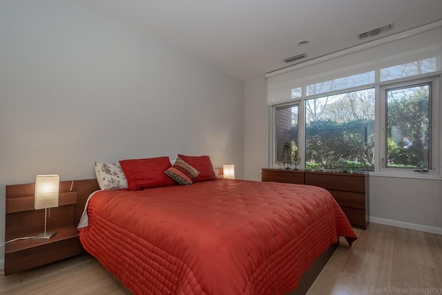 bedroom featuring light wood-style floors and baseboards