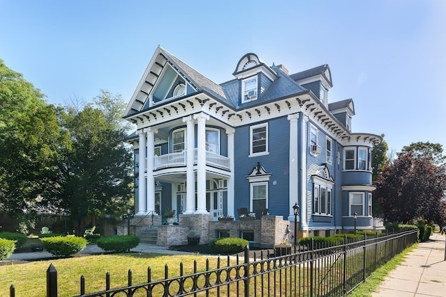 view of front of property with a porch, a front yard, and a balcony