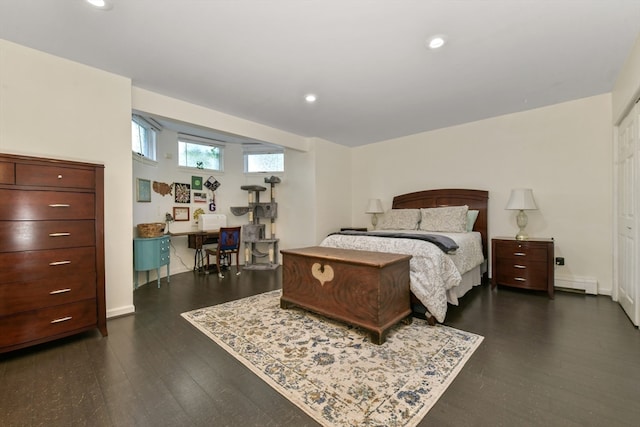 bedroom with dark hardwood / wood-style floors and baseboard heating