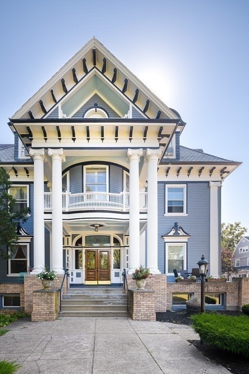 view of front of home with french doors, covered porch, and a balcony