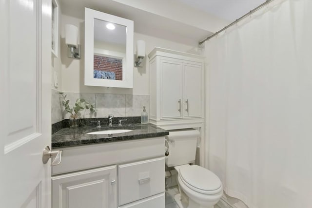 bathroom featuring backsplash, toilet, and vanity