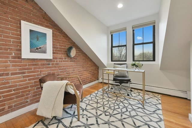 office with light hardwood / wood-style floors, brick wall, and a baseboard radiator