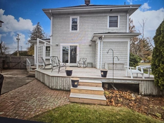 back of house with a chimney, fence, a patio, and a wooden deck