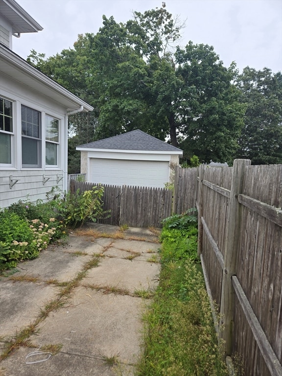 view of yard with a garage and an outbuilding