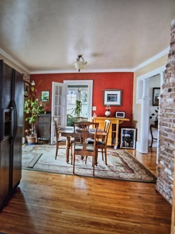 dining area with crown molding and hardwood / wood-style floors