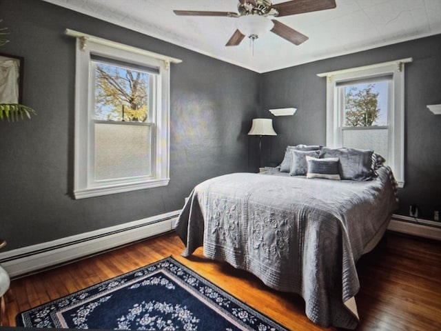 bedroom with a baseboard radiator, ceiling fan, and hardwood / wood-style flooring