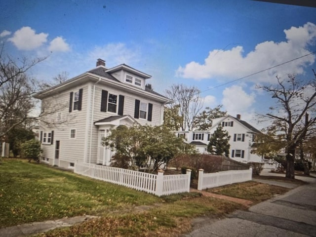 view of front facade with a front lawn and a fenced front yard