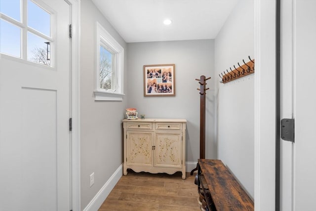 doorway featuring light wood finished floors, recessed lighting, and baseboards