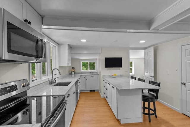 31 Brookside Dr, North Smithfield, RI 02896 - kitchen with appliances with stainless steel finishes, a sink, light stone countertops, a breakfast bar, and ornamental molding