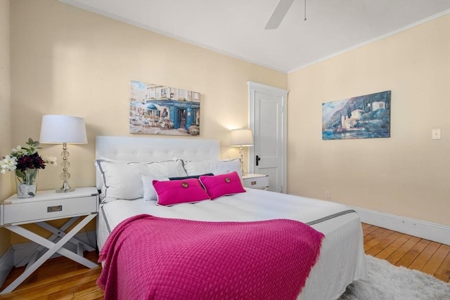 bedroom with crown molding, baseboards, wood-type flooring, and ceiling fan