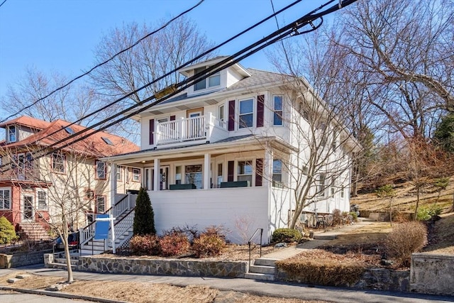 traditional style home featuring stairs, a porch, and a balcony