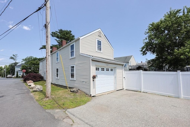 137 High St, Danvers, MA 01923 - view of side of property featuring a garage, driveway, and a chimney