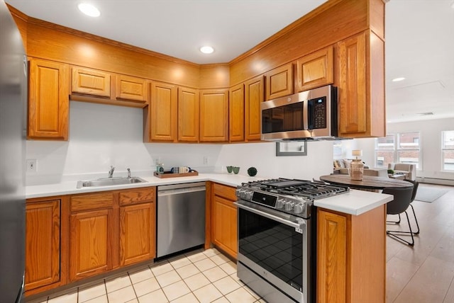 1 Davenport St Unit 11, Cambridge, MA 02140 - kitchen featuring appliances with stainless steel finishes, a sink, light countertops, brown cabinets, and recessed lighting