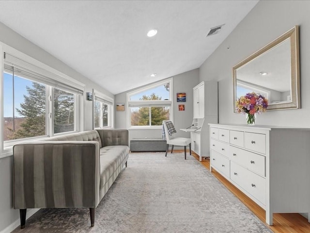 interior space with visible vents, light wood-style flooring, recessed lighting, baseboards, and lofted ceiling