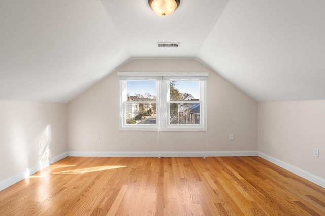 additional living space with vaulted ceiling and light hardwood / wood-style floors