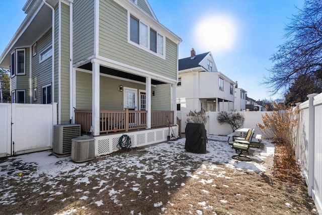 snow covered back of property with central AC unit