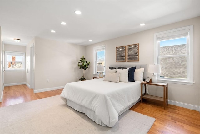 bedroom with multiple windows and hardwood / wood-style floors