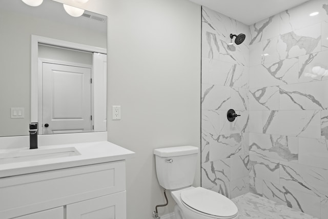 bathroom featuring vanity, toilet, and tiled shower