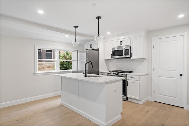 kitchen featuring sink, white cabinets, decorative light fixtures, and appliances with stainless steel finishes