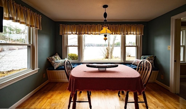 dining space featuring light wood-style flooring and baseboards