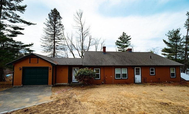 view of front of property with roof with shingles, a chimney, a garage, and driveway