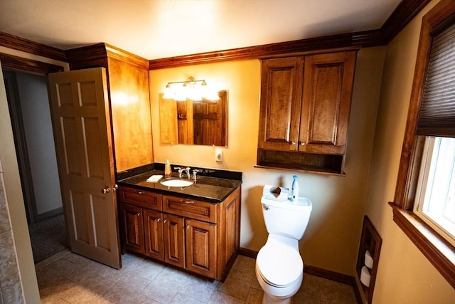 bathroom with toilet, vanity, and baseboards