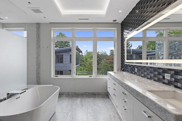 bathroom featuring plenty of natural light, tasteful backsplash, tile floors, and vanity