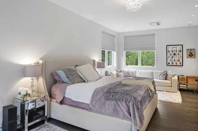 bedroom featuring a chandelier and dark wood-type flooring