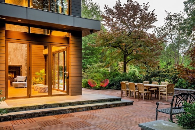 wooden terrace featuring a patio and exterior fireplace