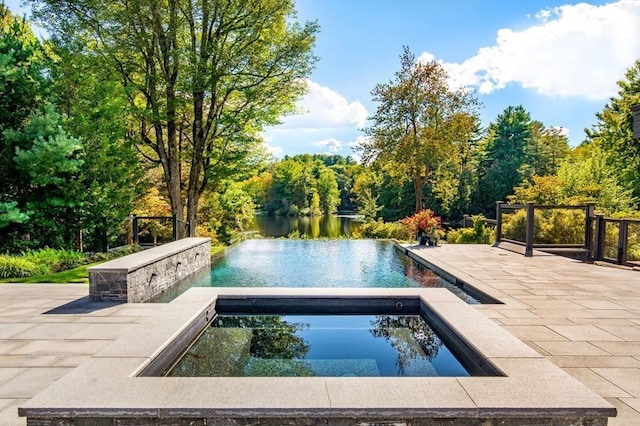 view of pool with a patio and an in ground hot tub